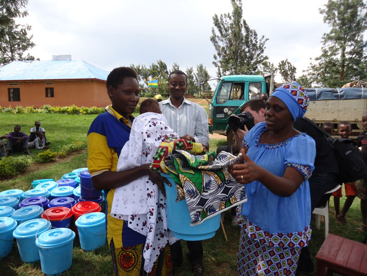 Umuyobozi w'akarere wungirije ushinzwe imibereho myiza aha umwe mubagenewe imfashanyo yatanzwe na UN WOMEN.