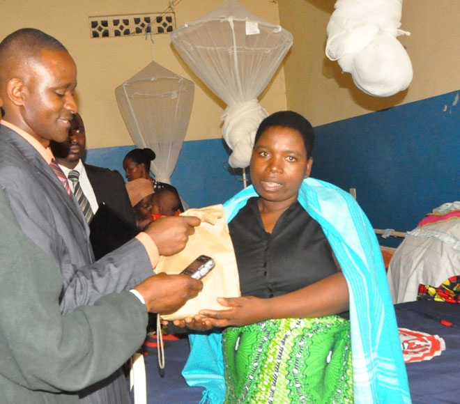 Umuyobozi w'ibitaro bya Ruhengeri, Dr Ndekezi Deogratias, aha ubufasha umurwayi.