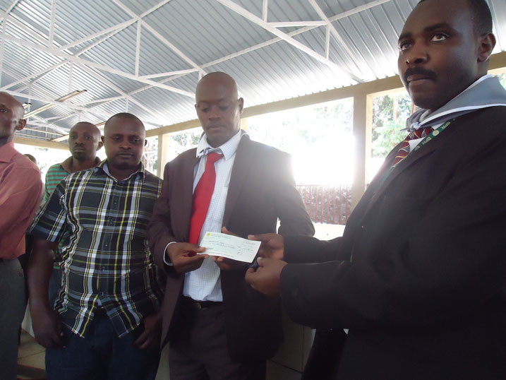 Umuyobozi wa Banki y'Abaturage, Ishami rya Karongi ashyikiraza Perezida wa Ibuka mu Karere ka Karongi sheki y'amafaranga miliyoni.