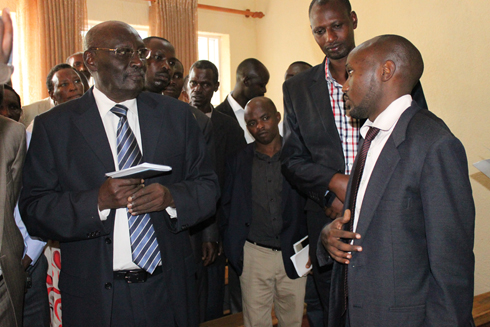 Umuyobozi wa SACCO (ibumoso) n'Umunyamabanga Nshingwabikorwa basobanurira umuyobozi mu kigo cy'imiyoborere uko My SACCO itanga serivisi.