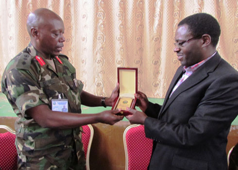 Umwarimu mu ishuri rya gisirikare rya Nyakinama ashyikiriza umuyobozi w'akarere ka Gakenke impano.