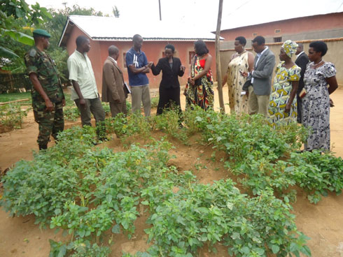 Umwe mu banyamuryango arereka abamusuye uko imboga zabashije kumuteza imbere.