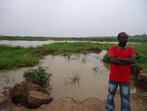 Uyu ahagaze munsi y'inzu ye aho amazi yenda kumusanga mu nzu.