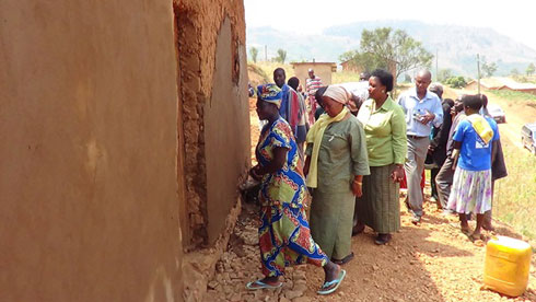 Nyirakamana yinjiza abamusuye mu nzu nshya yubakiwe.