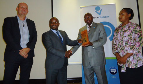 Lamin Manneh ukuriye UN mu Rwanda ashyikiriza minisitiri Jean Philbert Nsingimana/MYICT, ikimenyetso cy