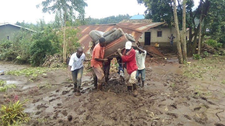 Abangirijwe n'imvura barimo kubikisha ibintu byabo.