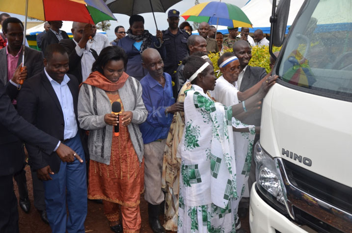 Abasaza n'abakecuru (n'ibyishimo byinshi) bakora ku modoka bahawe.