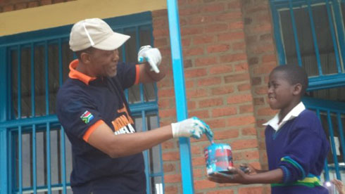 Umwe mu Banyafurika yepfo asiga irangi ku ishuri Groupe Scolaire de Bisate.