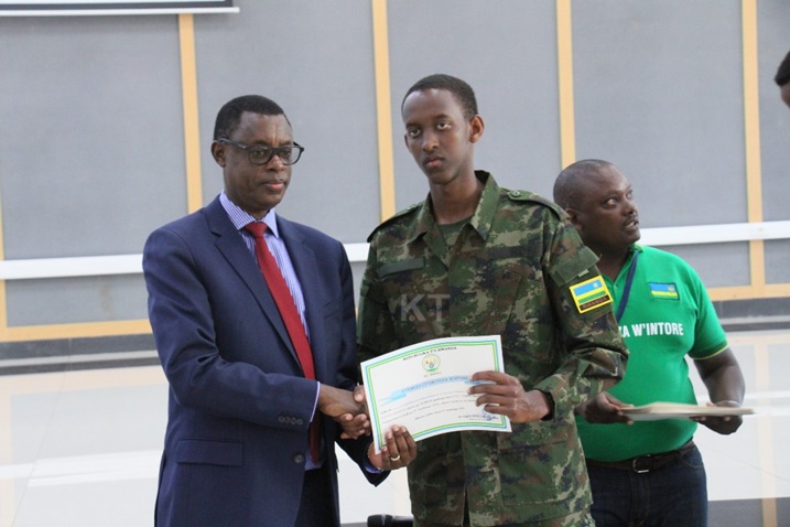 Minisitiri w'Ingabo James Kabarebe ashyikiriza Brian Kagame impamyabumenyi nyuma y'itorero.