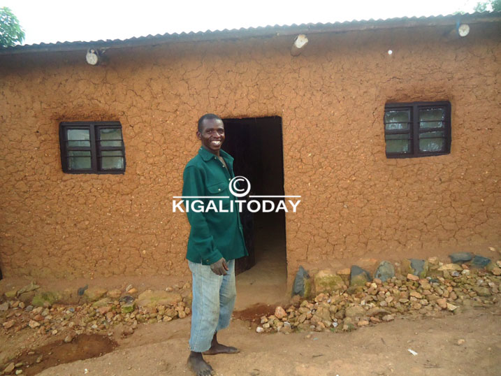 Ntawuziyambonye ahagaze imbere y'inzu ye.