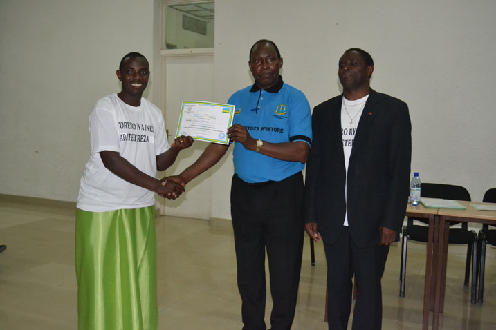 Umukuru w'Itorero ry'igihugu ashyikiriza umwe mu batoza b'intore muri INES icyemezo.