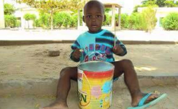 Uyu mwana ari kuvuza ingoma ku gikopo cya NIDO. Photo/ Internet