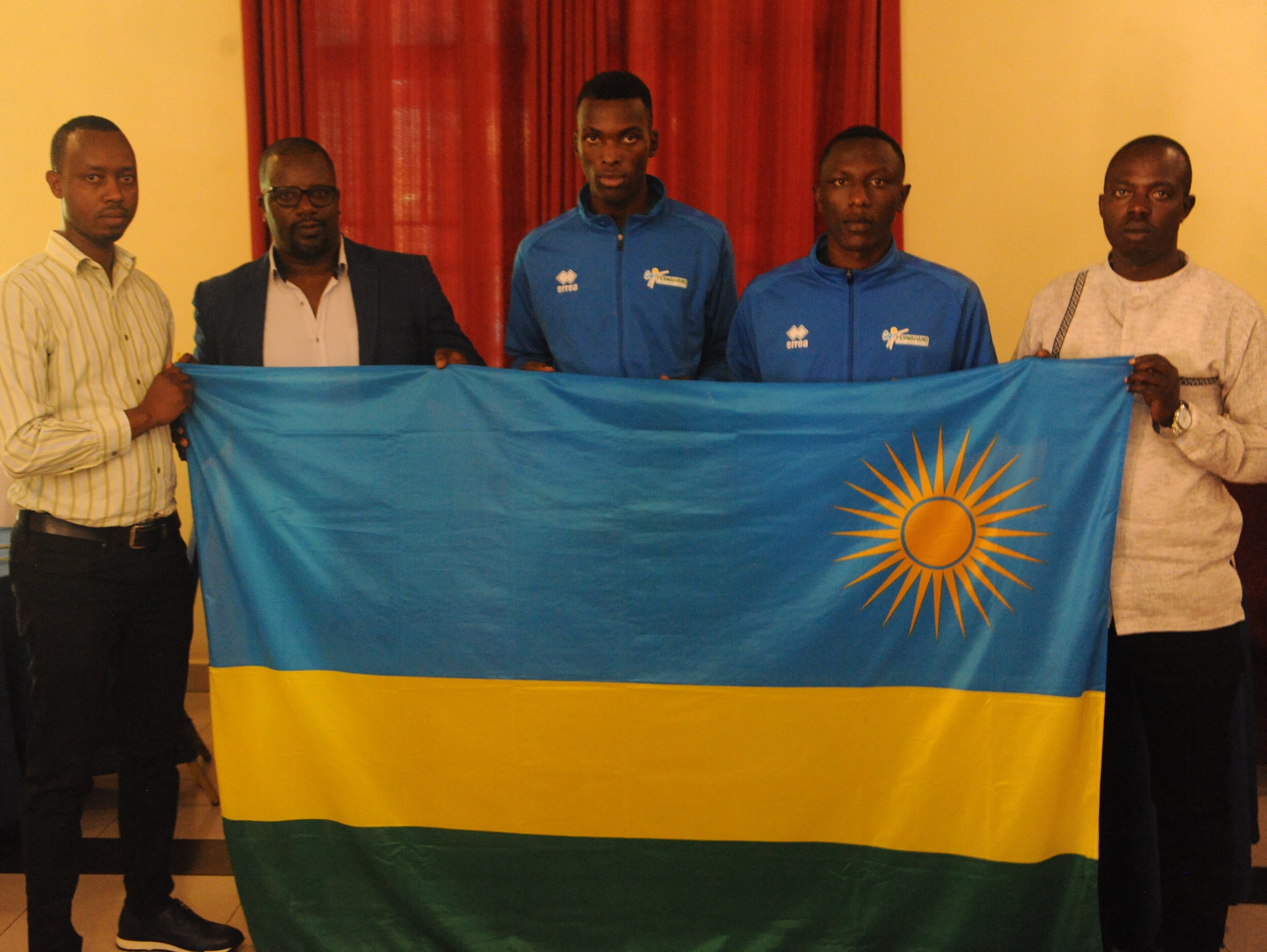 Umuyobozi wa Siporo w'agateganyo muri Minisiteri ya Siporo y'u Rwanda Munyanziza Gervais aha ibendera ry'igihugu iyi kipe