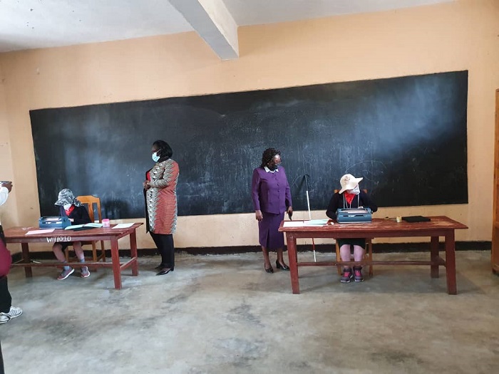 Guverineri Nyirarugero na Meya w'Akarere ka Musanze Nuwumuremyi Jeannine bareba uburyo abafite ubumuga bwo kutabona bakora ibizamini