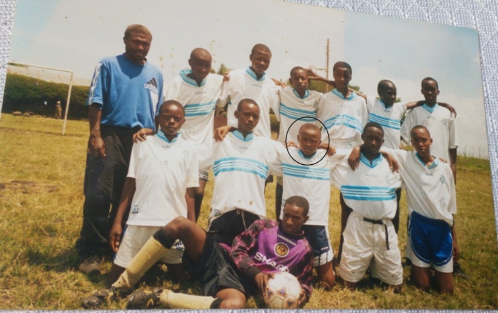 Ifoto igaragaza Tuyisenge ari umwana (uriho akamenyetso, upfukamye)