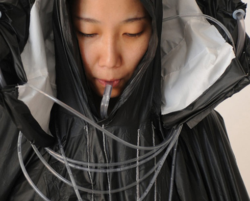 Uwambaye ikoti anywa amazi yasukuwe naryo.