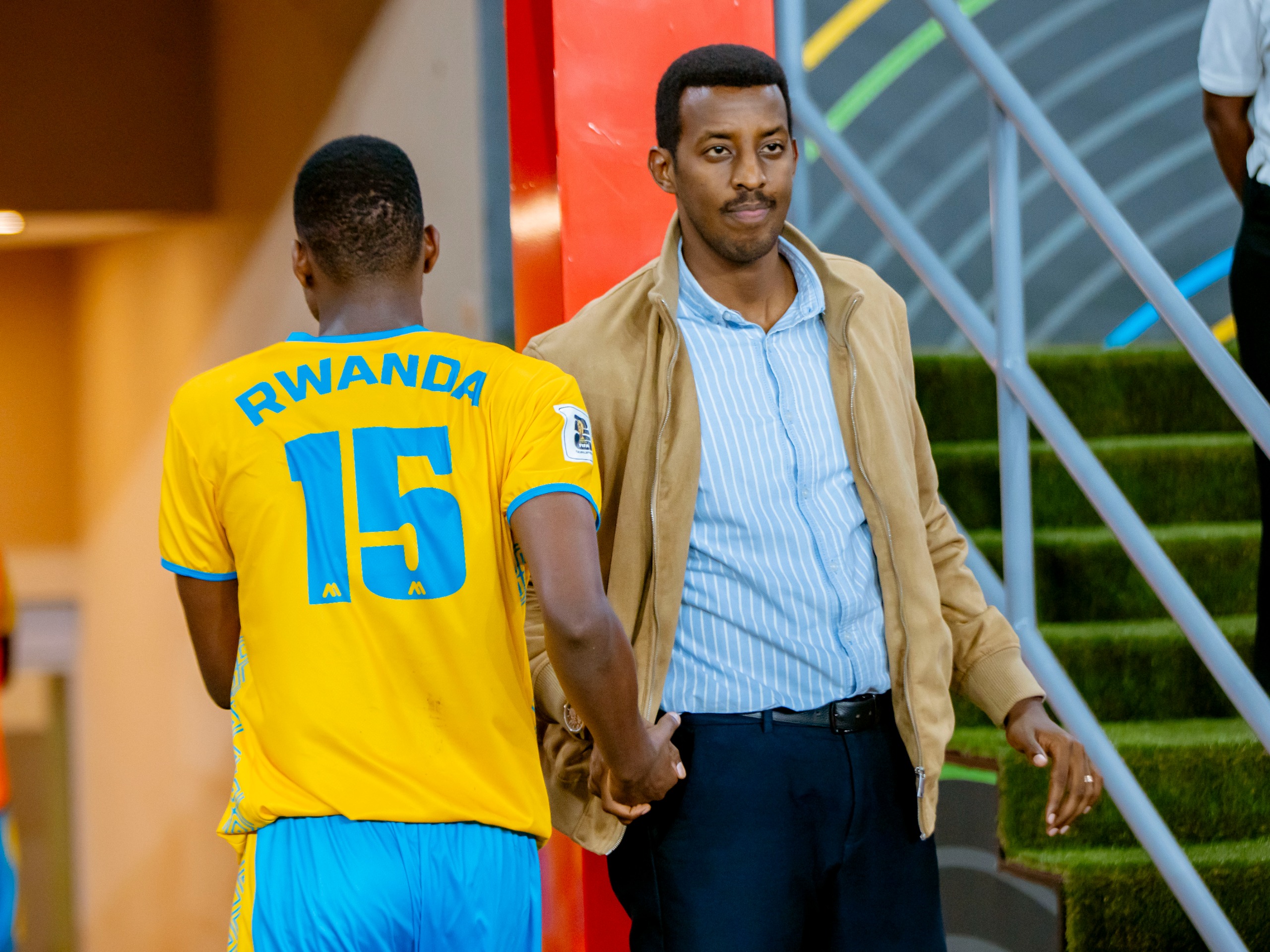 Umunyabanga wa Leta muri Minisiteri ya Siporo Rwego Ngarambe asuhuza Mugisha Bonheur nyuma y'umukino