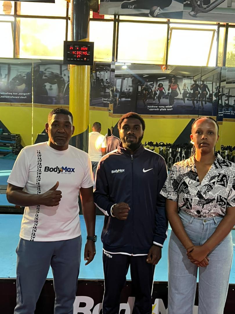 Niyonzima Pacifique (Uri hagati) ari kumwe na Perezida wa BodyMax Niyonsenga Karim(Ibumoso) ubwo yari amaze gusinya