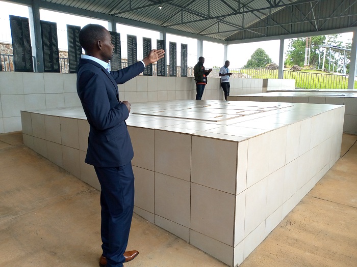 Umukozi wa CNLG yerekana imva ishyinguyemo Birara mu rwibutso rwa Bisesero