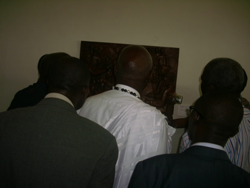 Sebukangaga Jean Baptiste ( hagati) asobanura uko igishushanyo cyerekana amateka y'Abanyarwanda.