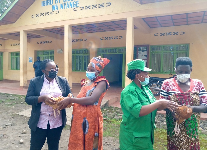 Visi Meya Kamanzi Axelle n'umwe mu bakozi ba DASSO bashyikiriza ababyeyi batwite inkoko zitera amagi