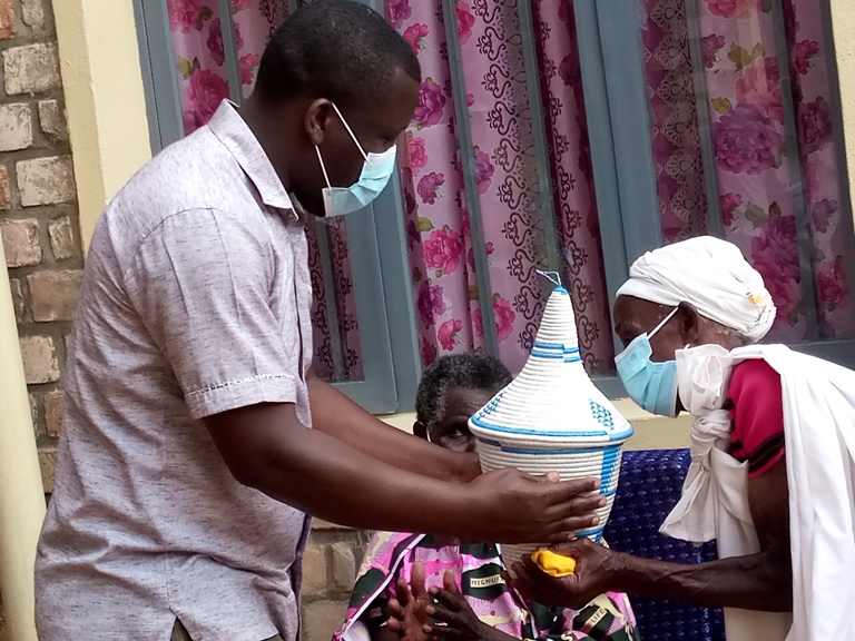 Bashyikirijwe inzu na Leta, ba mutimawurugo na bo barabaremera. Aha umuyobozi w'Akarere ka Nyamagabe, Bonaventure Uwamahoro, ari gufasha gushyikiriza umwe mu batujwe igiseke kirimo imyaka yazaniwe