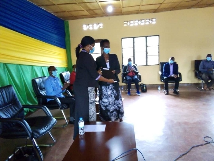 Mukabayire Valerie wa AVEGA Agahozo ashyikiriza Minisitiri Uwizeye irage rya Perezida Kagame(ifoto: RBA)