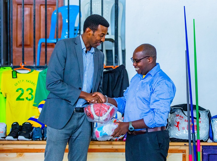 Rwego Ngarambe Umuyobozi Mukuru Ushinzwe Iterambere rya Siporo muri Minisports ashyikiriza Umuyobozi wa Lycée de Kigali ibikoresho