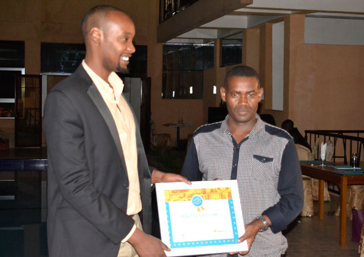 Alvin Katto ukuriye Kaymu mu Rwanda arashyikiriza igihembo umwe mu bacuruzi bakora neza mu koherereza abaguzi ibicuruzwa byinshi kandi byiza.