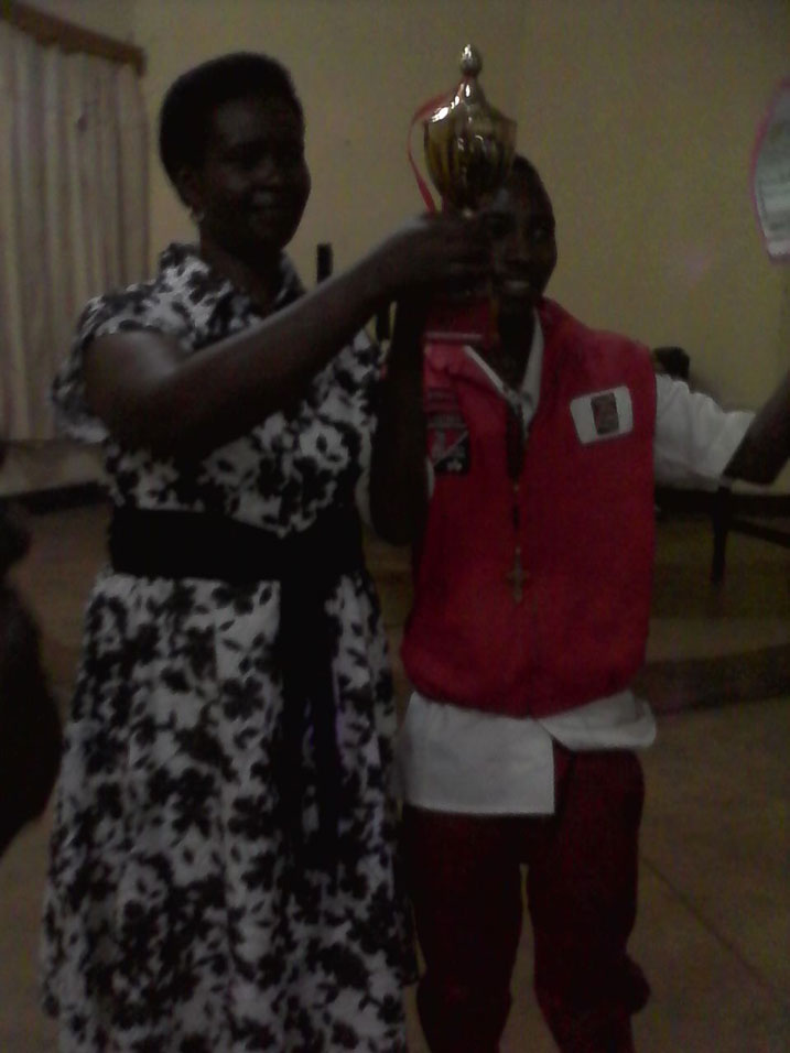 Umuyobozi w'akarere wungirije ashyikiriza Dig Dog igikombe.