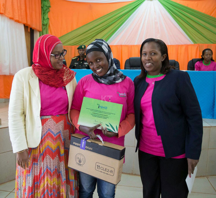 Kubwimana Josiane hagati ya Guverineri Odette Uwamariya na Hon. Harerimana Fatou, yishimira intambwe amaze gutera nyuma yo kwiga bimugoye.