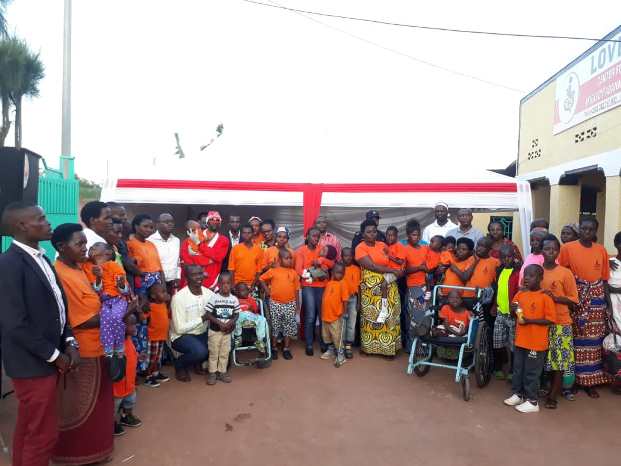 Kubwimana Gilbert (wicaye imbere wambaye umweru) hamwe n'imiryango irimo abana bafite ubumuga