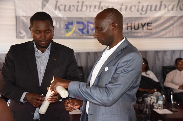 Perezida wa Ibuka mu Karere ka Huye (wambaye ikote ry'umukara) hamwe n'umuyobozi wa IPRC Huye bacana urumuri rw'ikizere