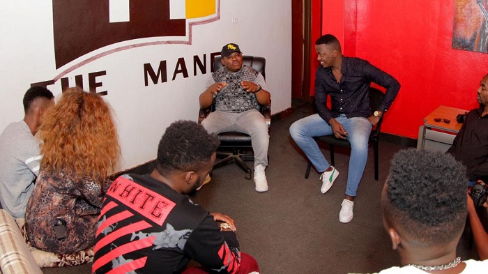 Mike Ogoke (wambaye ingofero) ubwo yari mu Rwanda, yasuye inzu ifasha abahanzi ya The Mane bagirana ibiganiro