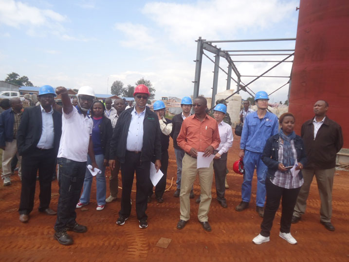 Minisitiri w'ibikorwa remezo, Prof. Lwakabamba Silas (wambaye ingofero itukura), yerekwa aho imirimo yo kubaka uruganda rwa nyiramugengeri igeze.