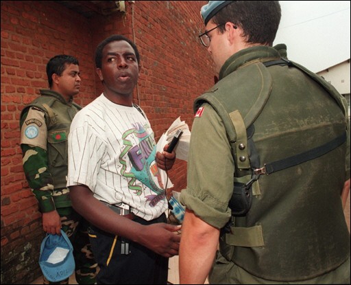 Munyeshyaka Wenceslas (uri hagati ufite imbunda nto ku rukenyerero) akekwaho kuba yaragize uruhare muri Jenoside yakorewe Abatutsi