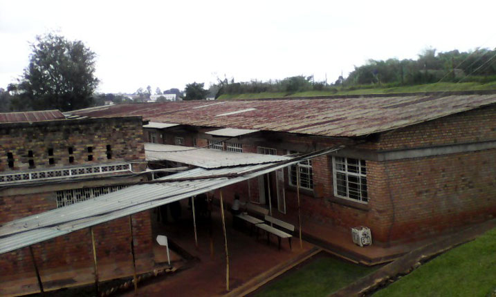 Ngo uwagerageza gusana igisenge cy'aya mazu kuko ava, yamanukana n'amabati ashaje cyane.