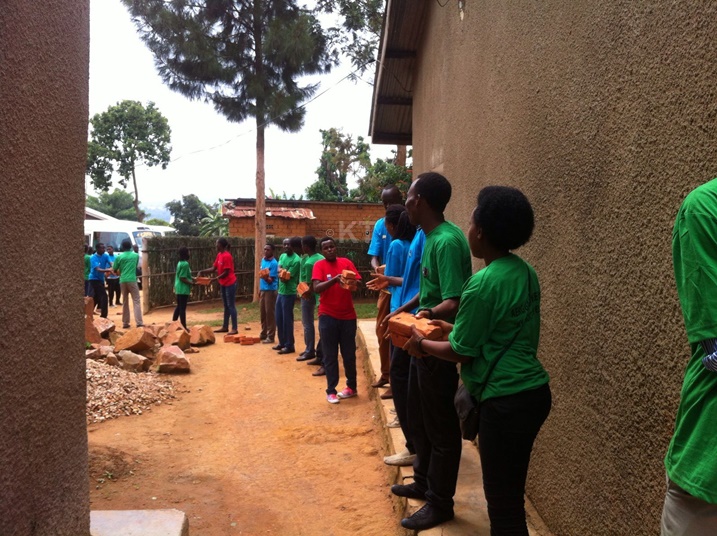 Barahererekanya amatafari yo kubaka inzu y'umukecuru.