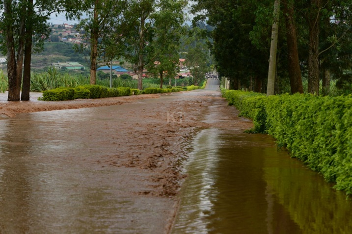 Amazi yuzuye arenga umuhanda.