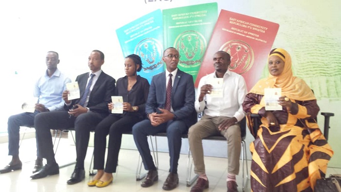 Batanu ba mbere ubwo bafataga pasiporo zikoranye ikoranabuhanga bari hamwe n'Umuyobozi w'Urwego rw'Abinjira n'Abasohoka (wambaye indorerwamo)