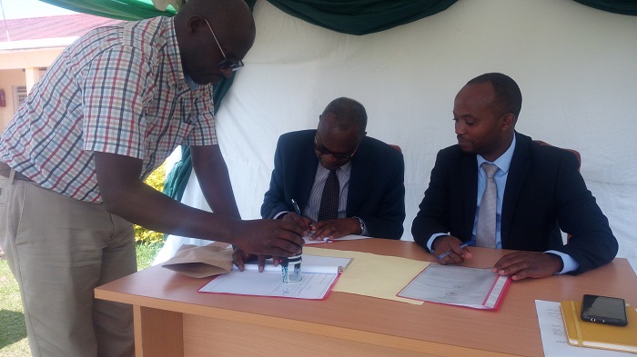 Umunyamabanga nshingwabikorwa w'umurenge wa Tumba Vital Migabo (iburyo), hamwe n'umuyobozi mukuru wa PIASS , basinye amasezerano y'imikoranire