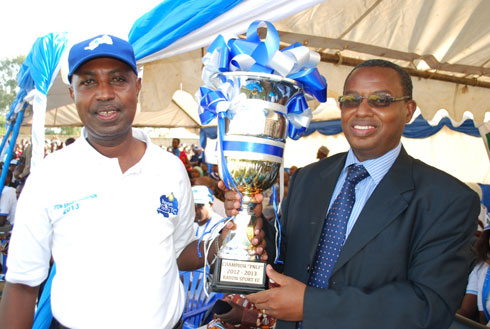 Abantu batandukanye bifotoje ku gikombe Rayon Sports yatwaye.