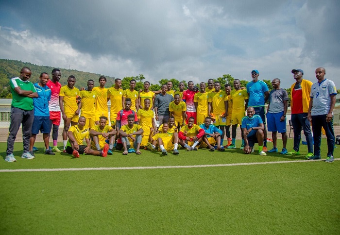 Michel Rusheshangoga yafashe ifoto y'urwibutso n'abakinnyi bakinanaga muri AS Kigali 