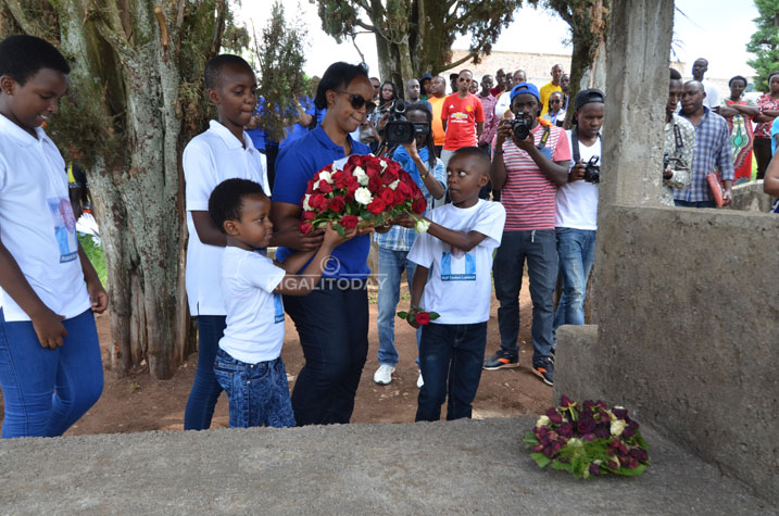 Umuryango wa Byemayire Lambert ushyira indabo aho Nyakwigendera ashyinguye