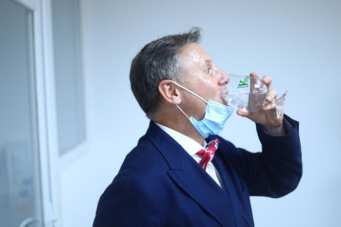 Umuyobozi Mukuru wa SKOL Brewery Ltd, Ivan Wulffaert, anywa ku mazi yakozwe n'uruganda ayobora