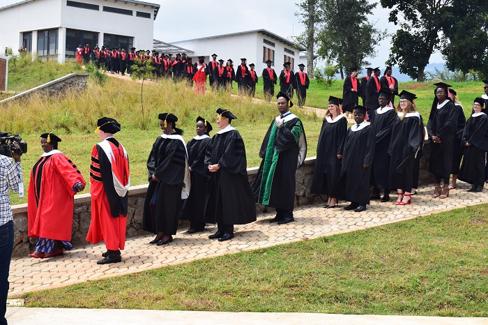 Abanyeshuri bahawe impamyabumenyi bakoze umutambagiro bari inyuma y'abayobozi 