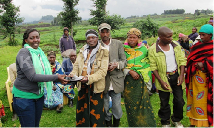 Umukozi wa MIDIMAR Umugwaneza ashyikiza abatahutse amasuka yo guhingisha.