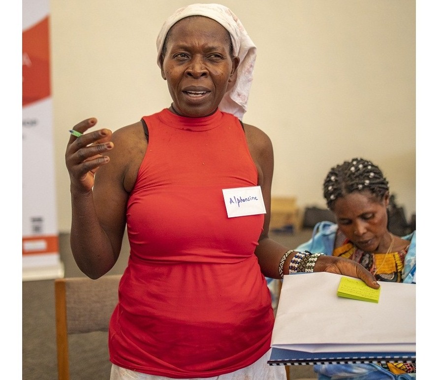 Umubyeyi wa Nteziryayo mu mahugurwa ku Rwibutso, yambaye udukomo twakozwe n'umuhungu we