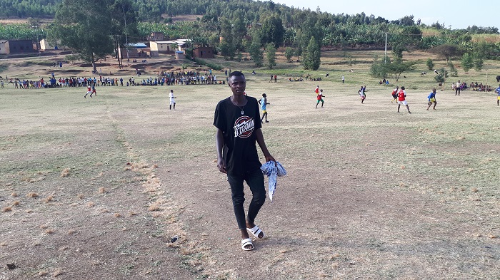 Umusifuzi wo ku ruhande aragenda mu kibuga umukino urimo kuba