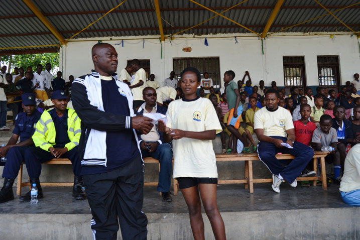 Umuvunyi wungirije ashyikiriza umukobwa wabaye uwa mbere igihembo cye.